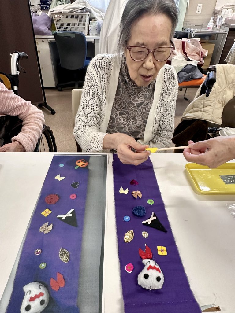職員と一緒にタペストリーを制作する利用者さま