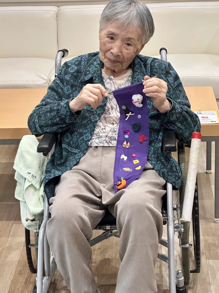 完成したタペストリーを紹介する利用者さま